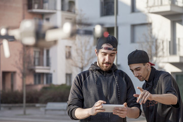 young guys are flying a drone with remote control outdoor - obrazy, fototapety, plakaty