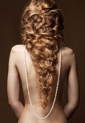 Model with long hair. Waves Curls Hairstyle. Hair Salon. Updo. Fashion model with shiny hair. Woman...