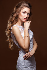 Naklejka premium Beautiful Bride portrait wedding makeup and hairstyle with long curly tress, fashion bride model jewelry and beauty girl face, gorgeous beauty bride, isolated , studio. Chocolate background.