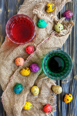 Fototapeta na wymiar Painted quail eggs and paint in the glass.