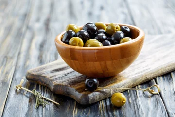 Foto op Plexiglas Green and black olives in a wooden bowl. © sriba3