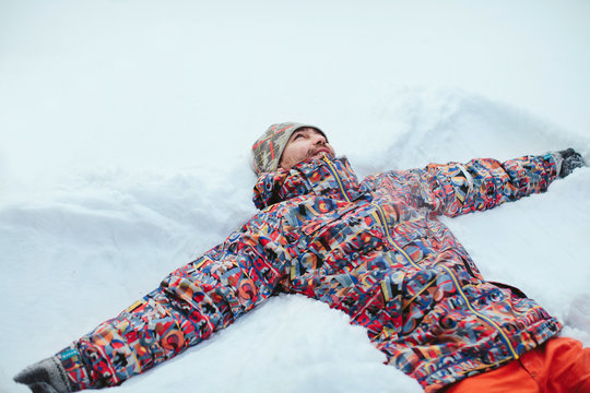 Man Lying In Snow Making Snow Angel