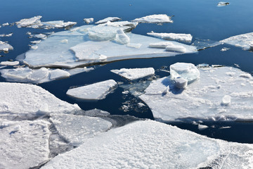 Spring. Drifting ice on the river. White ice floes floating on blue water. Natural background © Katvic