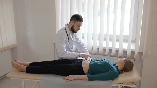 Doctor palpates the abdomen of young girl