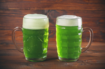 St Patrick's Day concept two mug green beer against wooden background