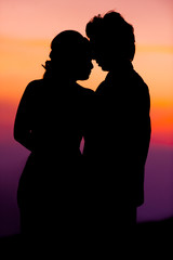 Fototapeta na wymiar Silhouette of Embracing Asian Bride and Groom at Sunset