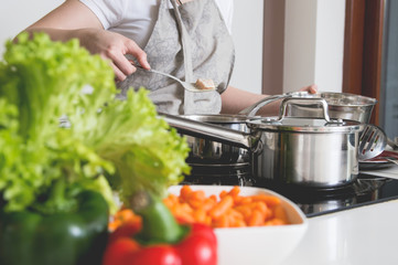 Woman prepares a meal made out of chicken and vegetables. Conception of healthy nutrition.