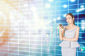 Businesswoman with trading online on smartphone with stock graphics on the background