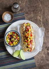 Mexican street style hot dog on wooden background, top view.