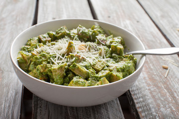 Roasted Sweet Potatoes with Creamy Kale Sauce Pesto with Parmesan on dark brown table horizontal shot