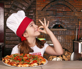 happy little girl cook with pizza and ok hand sign in pizzeria