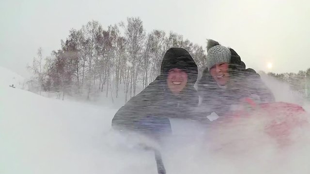 happy family rides and smiling snowtube on snowy roads. slow motion. snow winter landscape. outdoors sports