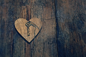 key and wooden heart on rustic wooden background. heart, symbol of love, romance. February 14, Valentine's day concept. template for design. copy space