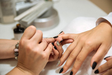 Manicure process in beauty salon, close up. Black nails