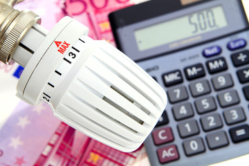 Symbol photo heating cost, heating thermostat with euro bills and calculator