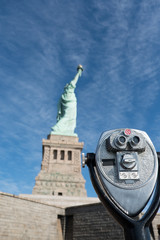 Tower viewer telescope that looks like a face in front of the Statue of Liberty on Liberty Island,...