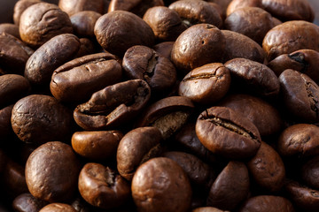 Coffee beans closeup. Macro photo of whole coffee beans. Whole coffee beans of Arabica and Robusta. Coffee texture, food photos.