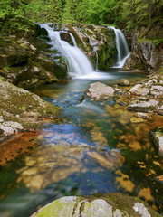 Waterfall and stream in the forest mountain valley