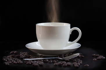 Hot cup of coffee in white on a dark background.