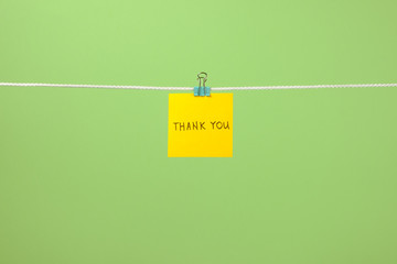 Yellow paper note on clothesline with text Thank You