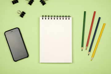 Top view of blank notebook page with colored pencils