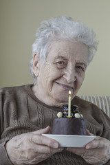 Senior woman holding her birthday cake