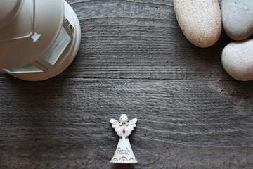 Background with angel and stones on a dark wooden table