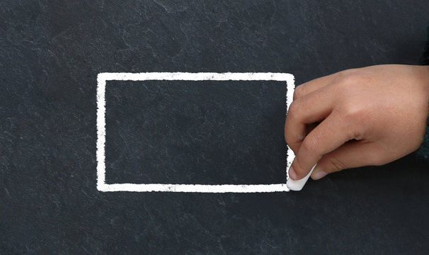 Enfant dessinant un triangle &agrave; la craie sur une ardoise