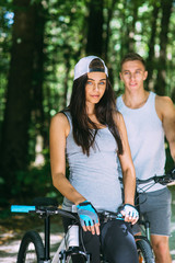 Obraz premium Young Couple Riding Bike In Park