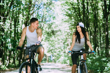 Young Couple Riding Bike In Park