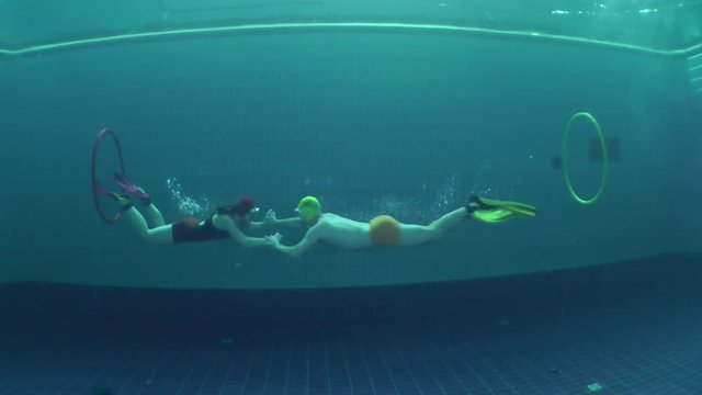 Battle of underwater fighters under the water, wide shot.