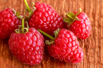 Rustic fresh ripe raspberries on brown background. Copy space. Close up. Front view.