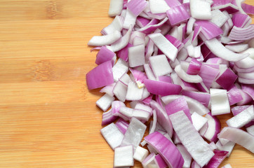 Sliced red onions on cutting wooden board background