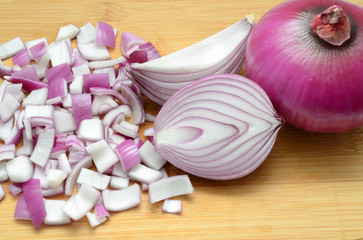 Sliced red onions on cutting wooden board background