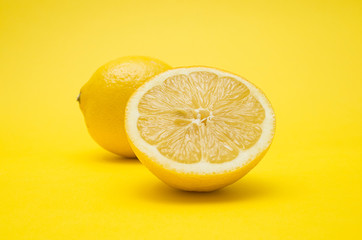 One and a half of lemon on yellow background