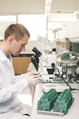 Microchip production factory. Technological process. Assembling the board. Computer expert. Manufacturing. Engineering. Chip. Professional. Technician.