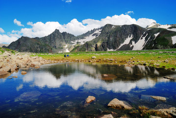 Fototapeta na wymiar Mountain Lake with clean water in the Caucasus summer. Blue sky with white clouds.