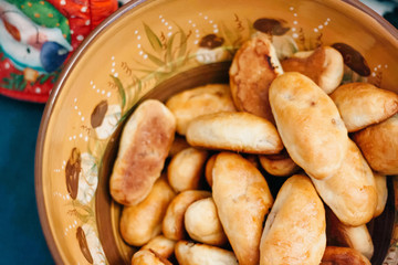 brown clay bowl with hot homemade meat pies buns