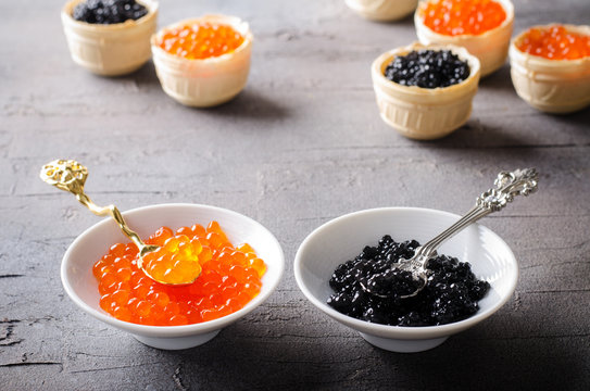 Black and red caviar tartlets, appetizer canapes in white bowls