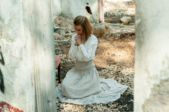 Mujer de rodillas lament&aacute;ndose