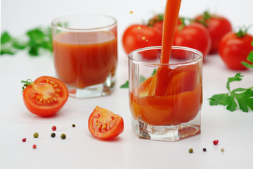 Tomato juice pouring into a glass.