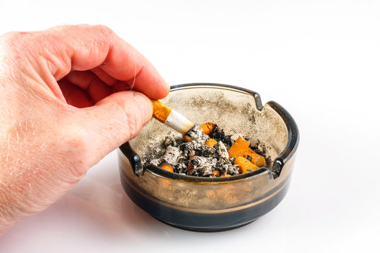 Close up of cigarette in ashtray on white background
