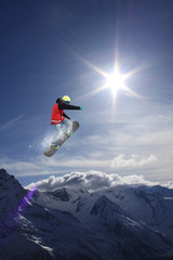 Snowboard rider jumping on mountains. Extreme snowboard sport.