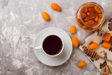 Obraz na płótnie Canvas Homemade kumquat jam in jar and fresh kumquats, top view