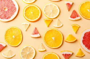 Fotobehang Citrusvruchten plakjes citroen, sinaasappel, grapefruit op gele achtergrond. © irynakolesova