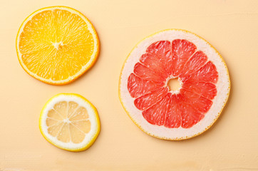 Citrus fruit slices of lemon, orange, grapefruit on yellow background.