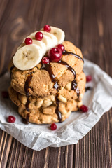 Peanut cookies with banana and berries on a wooden background