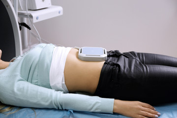 Magnetic therapy for young female patient in modern clinic