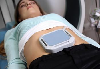 Magnetic therapy for young female patient in modern clinic, closeup