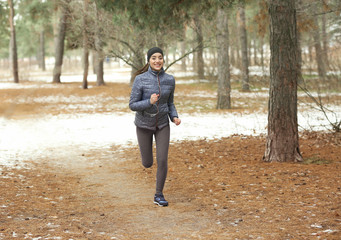 Young woman jogging in winter park